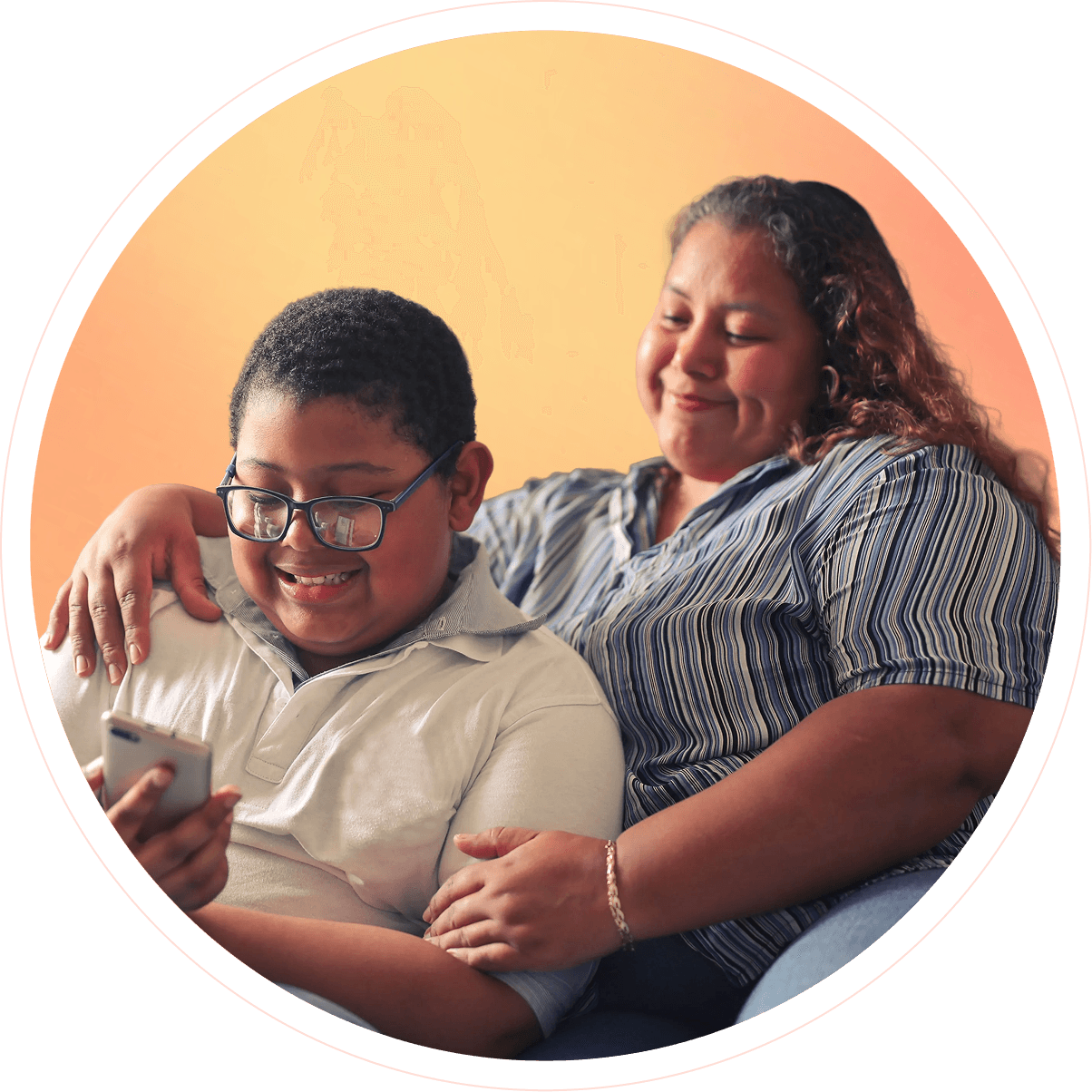 A mother and her son smiling together while looking at a phone